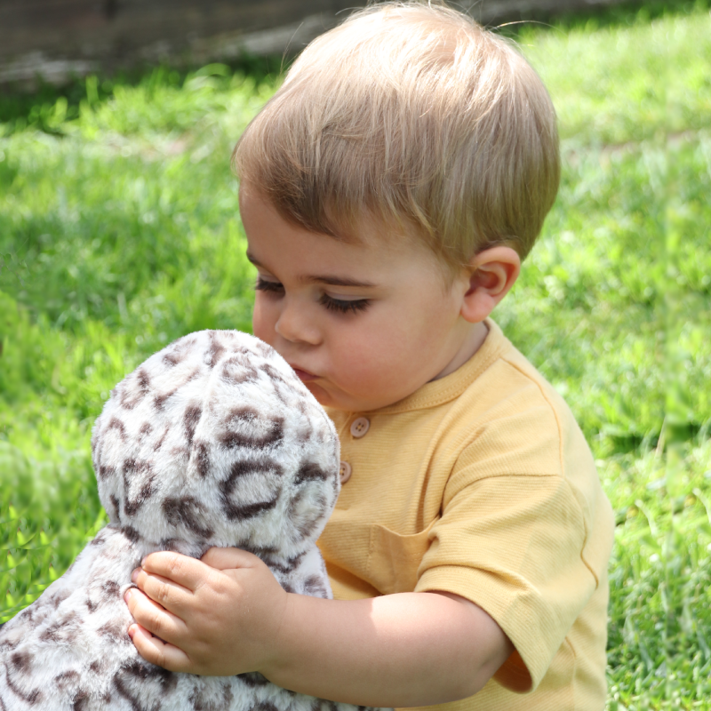 Little boy kissing a harbour seal pup plush toy