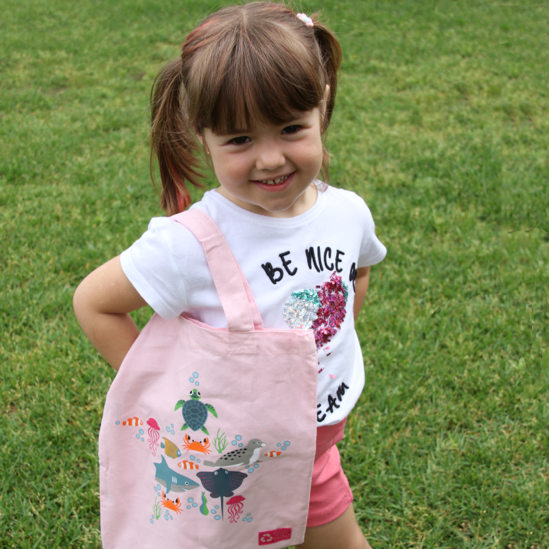 Little girl with a pink ocean motif tote bag